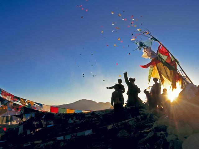 朝圣者将风马旗扔向甘登寺上方的空中为新年祈福，中国西藏