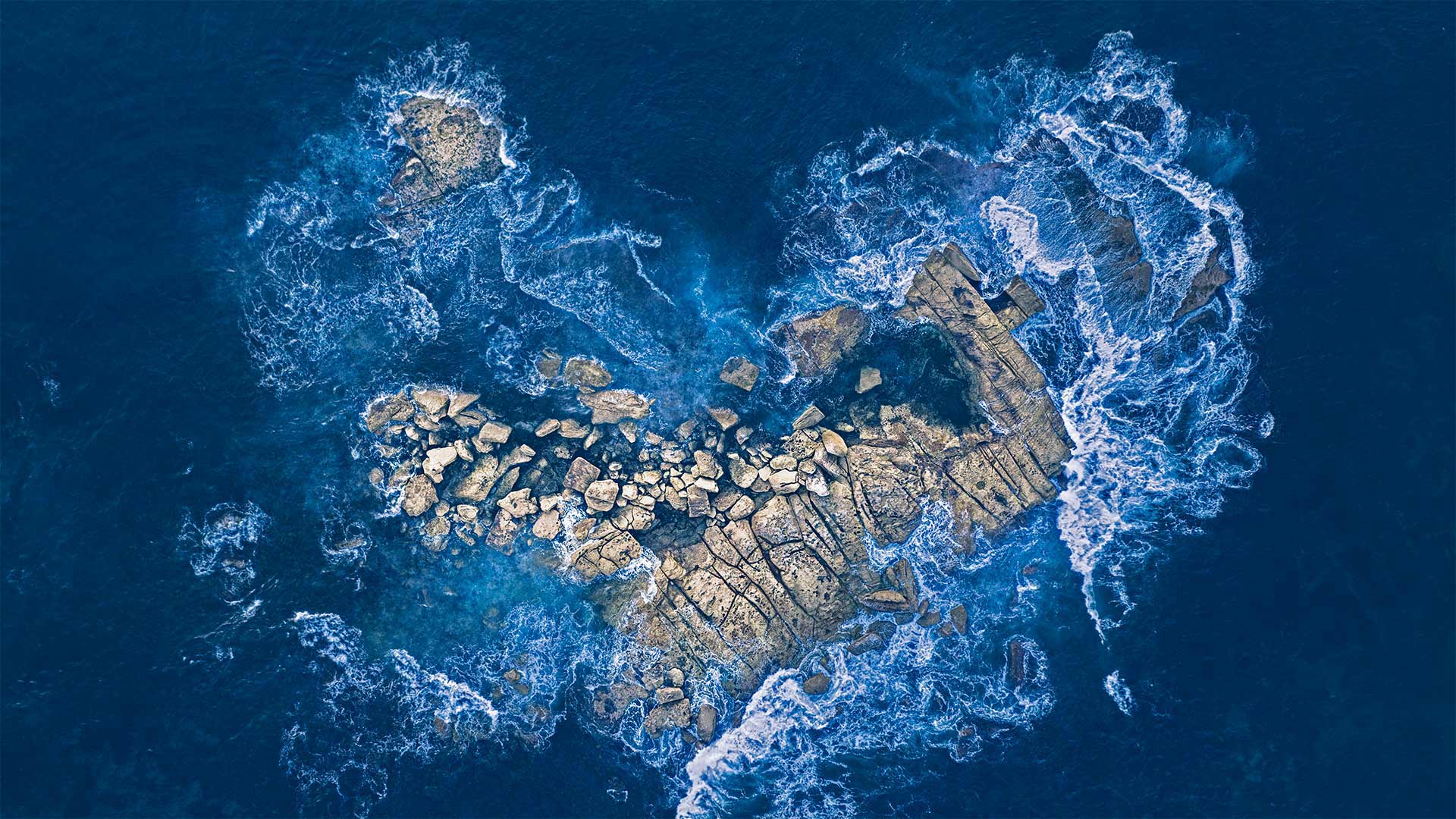 海浪冲击着悉尼海岸的一个心形岩石岛，澳大利亚