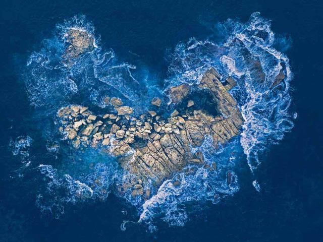 海浪冲击着悉尼海岸的一个心形岩石岛，澳大利亚